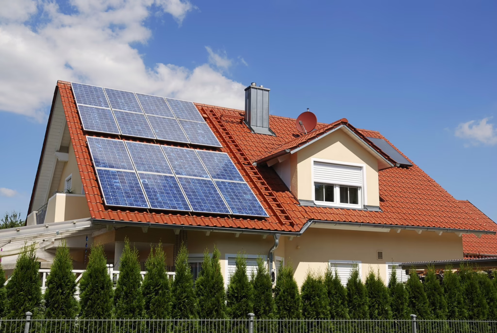 Ein Einfamilienhaus mit einer Photovoltaik-Anlage auf der einen Dachhälfte.